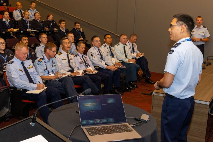 Leading Aircraftman Henry Lam (right) presents a speech during the Clear to Launch Symposium as part of the Air and Space Power Conference 2024, Canberra.