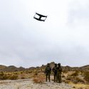 Australian soldiers standing on rocky, mountainous terrain operate an Unmanned Aerial Vehicle, or drone, as part of the 'Hyper-Teaming' experiment at Project Convergence Capstone 5, at Fort Irwin, California.