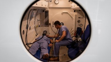 Leading Seaman medic Rhys Noblett (right) conducts medical training within the hyperbaric chamber at the Submarine and Underwater Medical Unit at HMAS Penguin.