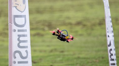 Small drone flying between two flags