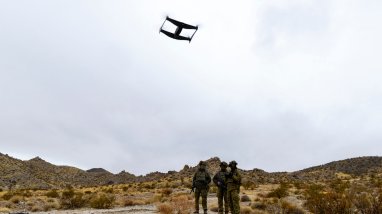 Australian soldiers standing on rocky, mountainous terrain operate an Unmanned Aerial Vehicle, or drone, as part of the 'Hyper-Teaming' experiment at Project Convergence Capstone 5, at Fort Irwin, California.