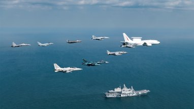 A Royal Australian Air Force E-7A Wedgetail leads a formation of aircraft past the Italian Navy aircraft carrier ITS Cavour during Exercise Pitch Black 2024.