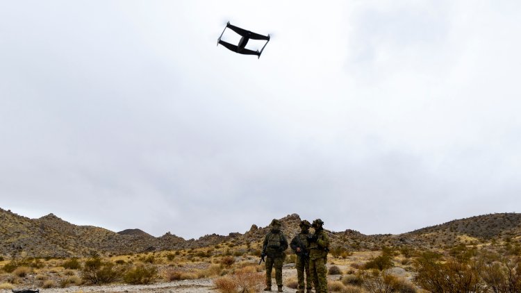Australian soldiers standing on rocky, mountainous terrain operate an Unmanned Aerial Vehicle, or drone, as part of the 'Hyper-Teaming' experiment at Project Convergence Capstone 5, at Fort Irwin, California.
