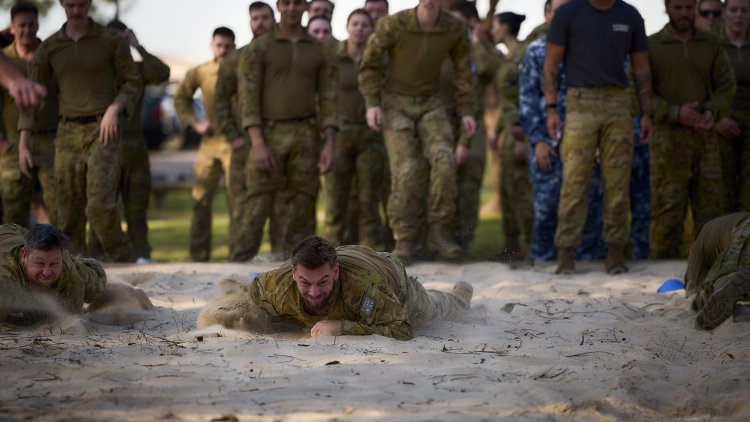 Combat Support Group members race to complete the leopard crawl component of the 2025 Charity Group Workout at RAAF Base Williamtown.
